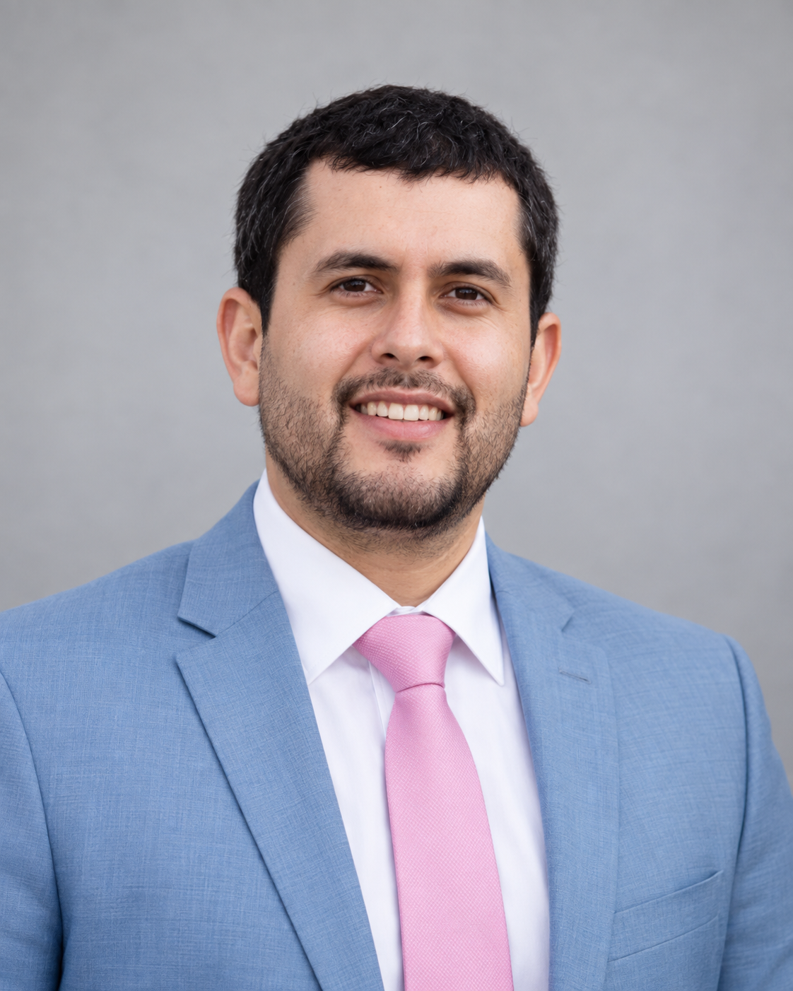 Raul Reynoso in a light blue suit and pink tie.